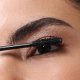 A close-up image of a person applying Nanolash mascara to their upper eyelashes using a wand.
