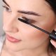 A woman skillfully uses a mascara brush to apply mascara