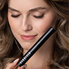 Woman with closed eyes holding Nanolash Length & Curl Mascara