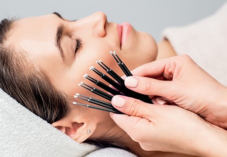 A handul of microbrush applicators held by a beautician